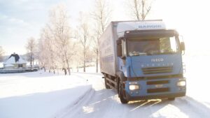 Un camion su strada innevata che rappresenta il servizio di trasporto su camion e trasporti internazionali offerto dalla ditta Baroni