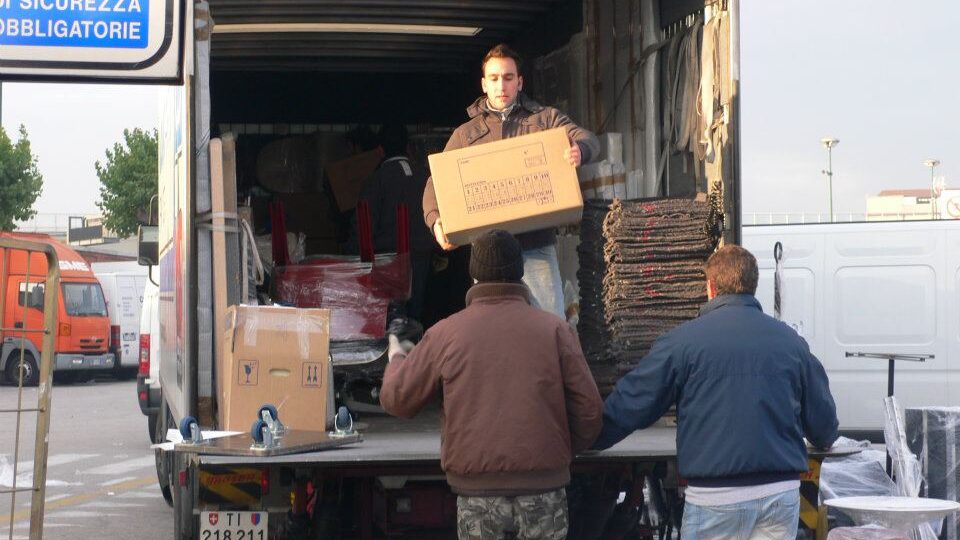 Bei einem Umzüge laden zwei Personen Pakete aus einem Lieferwagen
